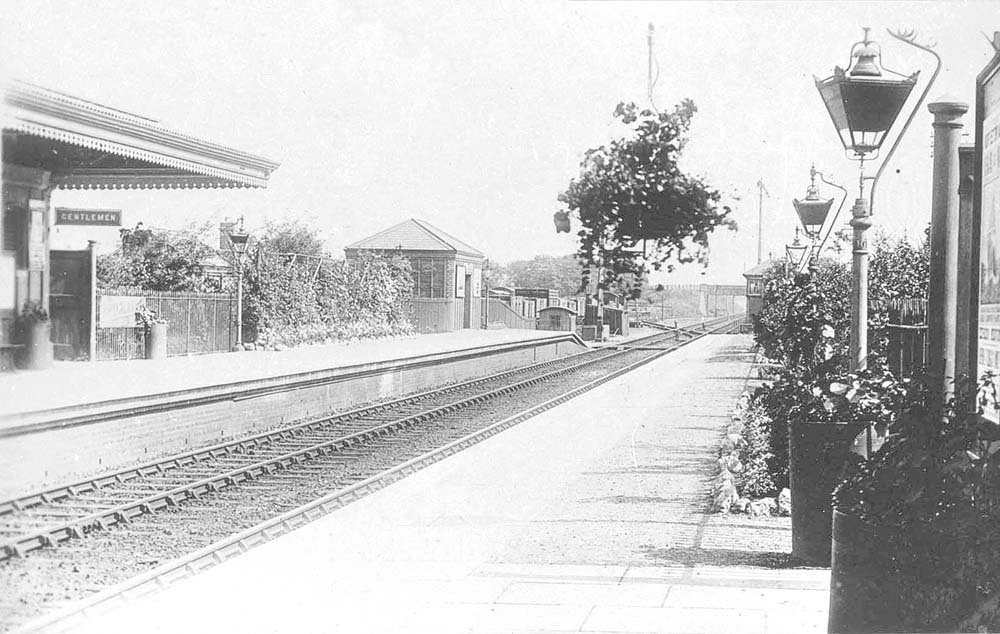 Looking towards Birmingham with the goods yard and a row of wagons seen in the distance at the end of the up platform on the left