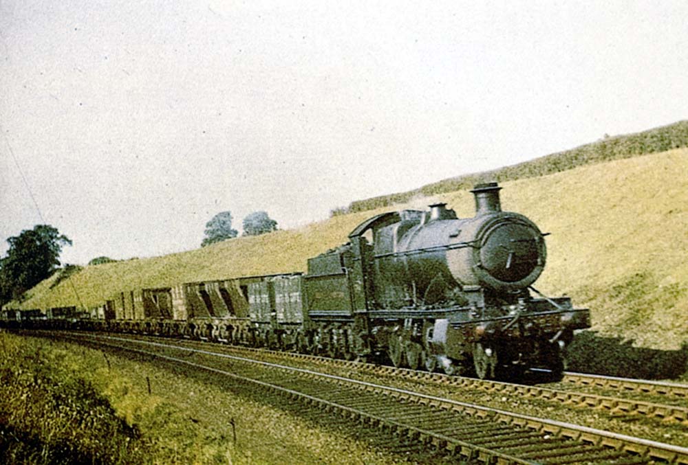 Great Western Railway 2-8-0 28xx class No 2834 hauling a class H unfitted through freight train of Iron Ore empties in Whitnash Cutting