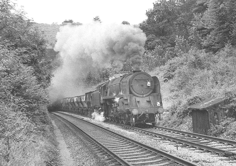 British Railways Standard Class 9F 2-10-0 No 92219 burst from Harbury tunnel on a mid morning southbound train of empty ore wagons