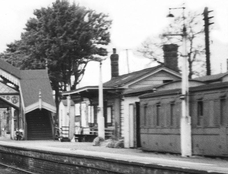 Close up showing the up platform building, a grounded coach body and corrugated iron buildings