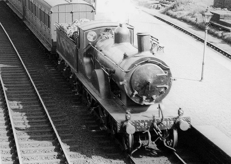 Close up showing the immaculately turned out ex-LSWR locomotive at the head of an down express train