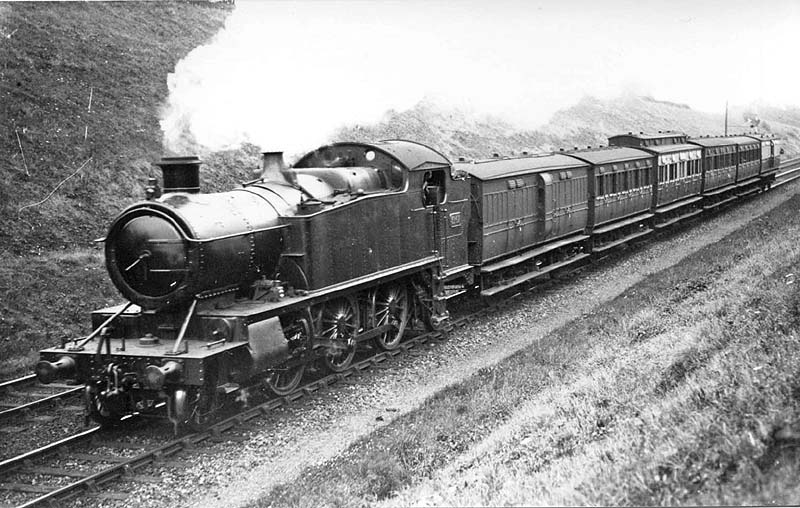 GWR 3150 Class 2-6-2T No 3167 is seen heading a down local passenger service comprising four and six wheel coaching stock