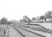 Looking towards the buffers with the shed on the left and the station master posed on the rails infront of the short station platform on the right