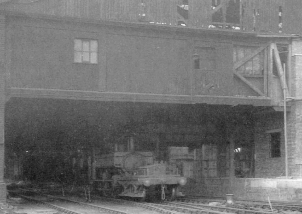 Close up showing an unidentified GWR 0-6-0PT and shunters truck standing on the middle road within the shed