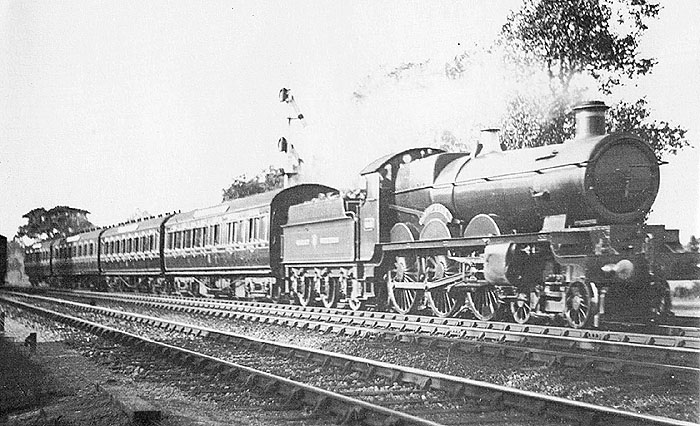An unidentified GWR 4-6-0 Star class at the head of a London bound express with coaching stock carrying crimson lake livery