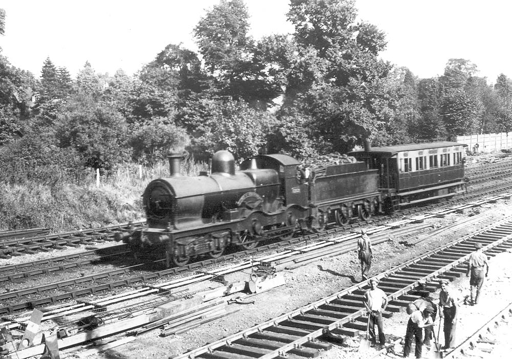 GWR 4-4-0 No 3252 'Duke of Cornwall', the founding member of the class, is seen with an inspection coach during the quadrupling of the lines