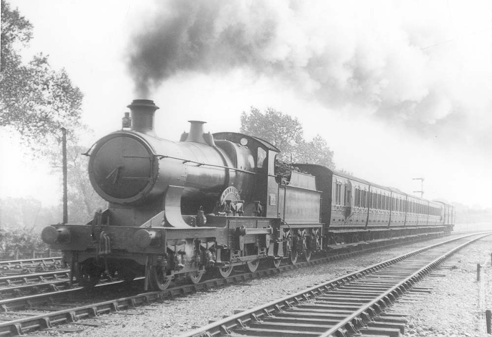 GWR 4-4-0 Straight-framed Bulldog class No 3404 'Barbados' is seen at the head of a rake of close coupled six-wheel stock near Knowle and Dorridge