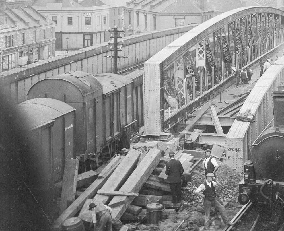 Close up showing workmen forming the deck to the new bridge together with adding other fixings to the bow girder