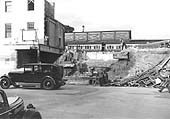 View showing the new station building being built in parallel with the old structure being demolished circa 1938