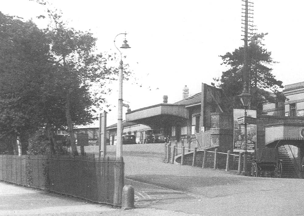 Close up showing motor taxis waiting on the upper level forecourt and canopy outside the main station buildings