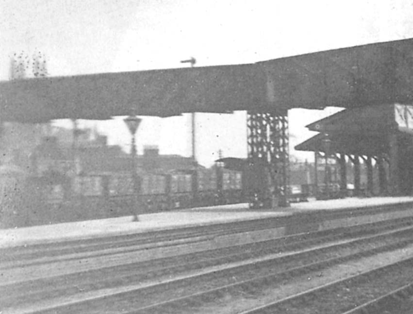 Close up showing a mineral goods train passing through the station on the goods loop which ran at the rear of the station