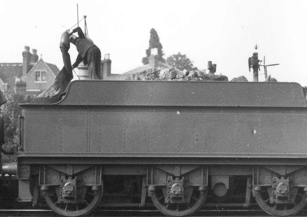 Close up showing No 6329's fireman struggling to place the 'bag in the hole' when filling the tender with water
