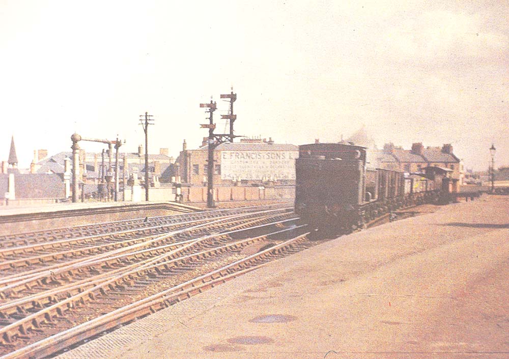 An unknown GWR 0-6-0PT locomotive travelling bunker first arrives at the south end of Leamington Spa station with a short freight train