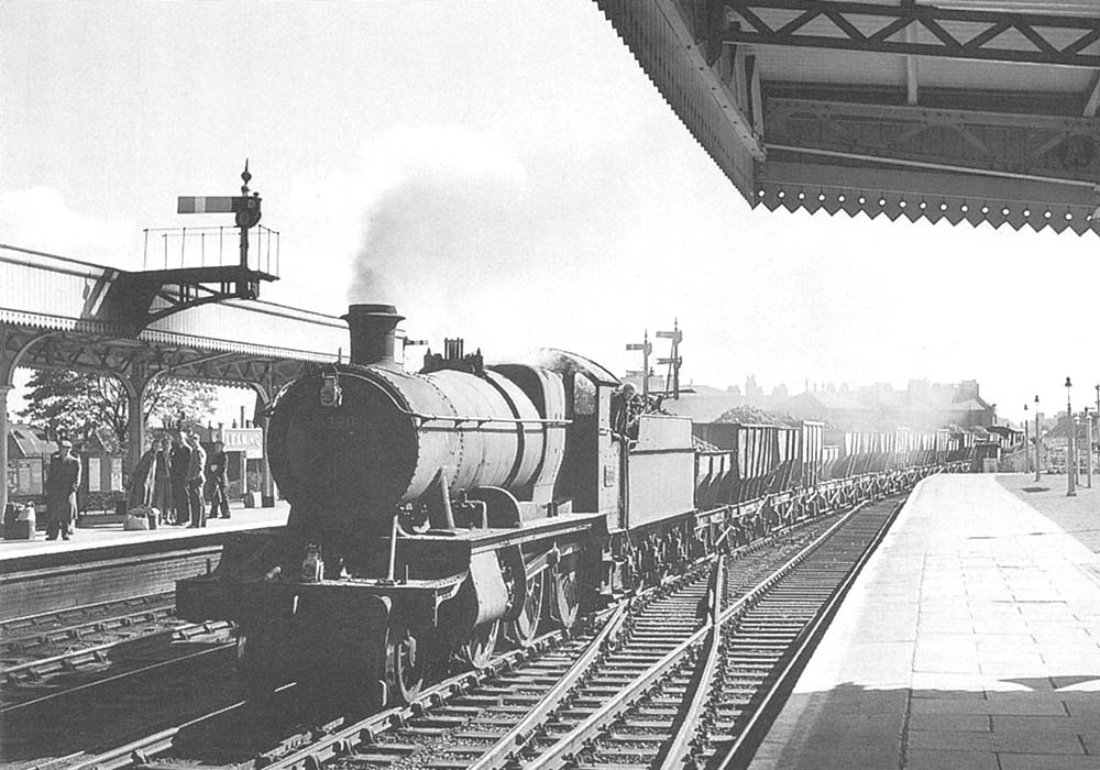 Ex-GWR 43xx Class 2-6-0 No 5390 trundles through the station with a down iron-ore train on 8th September 1957