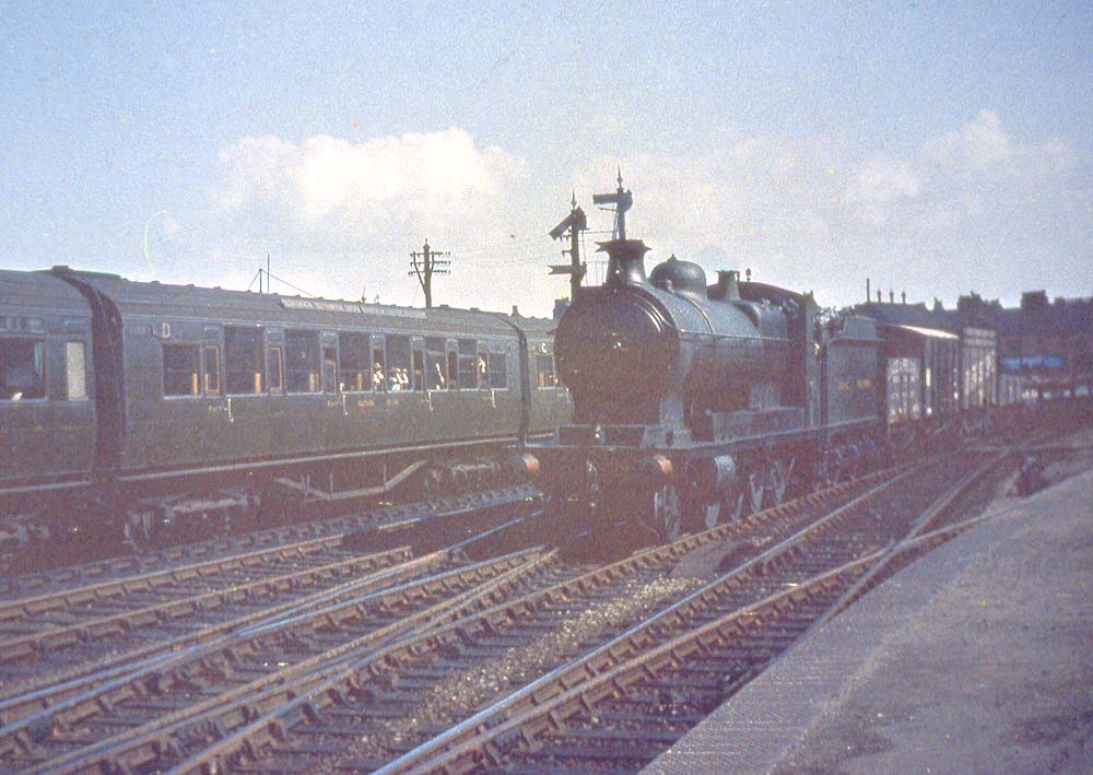 An unidentified ex-ROD or GWR 3100 class 2-8-0 passes through the station on down goods train