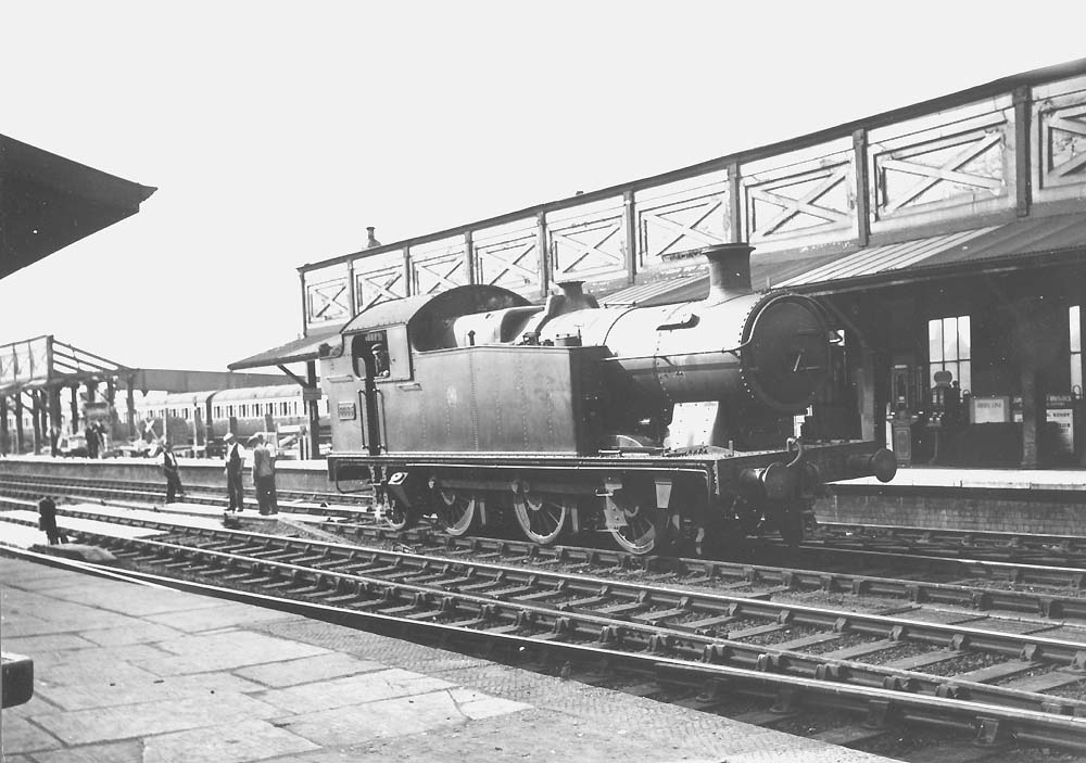 GWR 56xx class 0-6-2T No 6665 pauses on the up through road as it passes  through the station