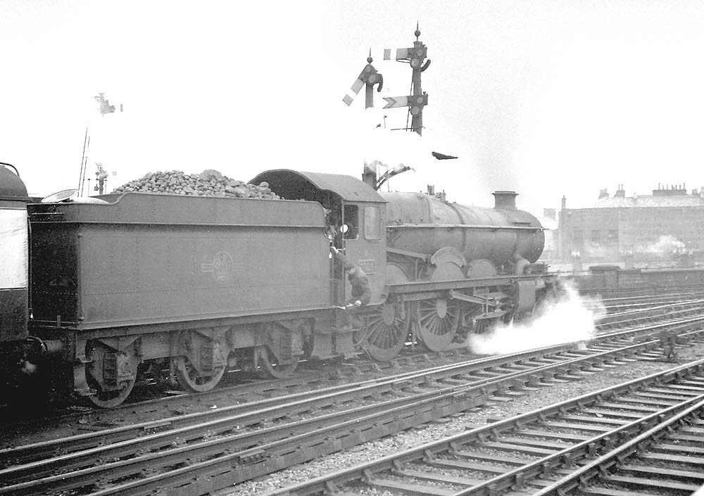 British Railways built 4-6-0 Castle Class No 7024 'Powis Castle' receives attention from the fireman at Leamington whilst on the up 'Inter City' on 20th April 1962