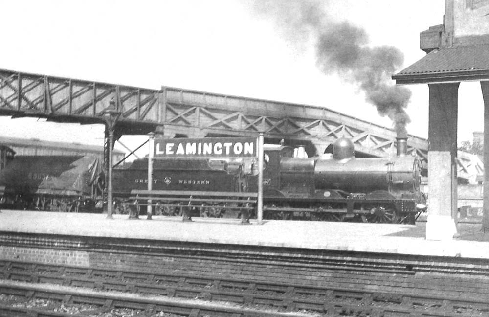 GWR 'Dean Goods' 0-6-0 No 2397 with a through goods train passing behind the station on the up goods loop