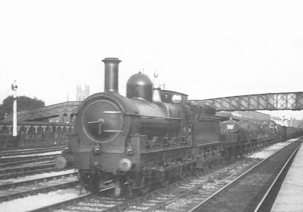 Unidentified Standard goods is seen passing through the station on a lengthy down goods train