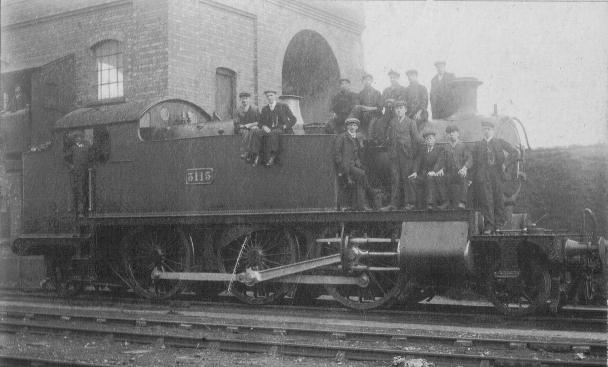 GWR 51xx Class 2-6-2T No 3115 stands in front of the coaling stage with members of the shed's staff posed on the running and footplate