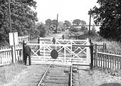 Looking towards the remains of Longdon Road in the direction of Shipston-on-Stour as the guard of the Moreton-in-Marsh goods train closes the gates