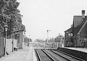 Close up showing the level crossing and the down refuge siding beyond the gates together with the waiting room built from vertical timber boarding