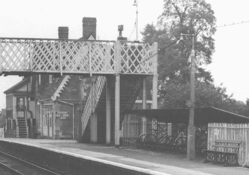 Close up showing the cycle shed erected at the base of the passenger footbridge with BR totem signs on the lamppost