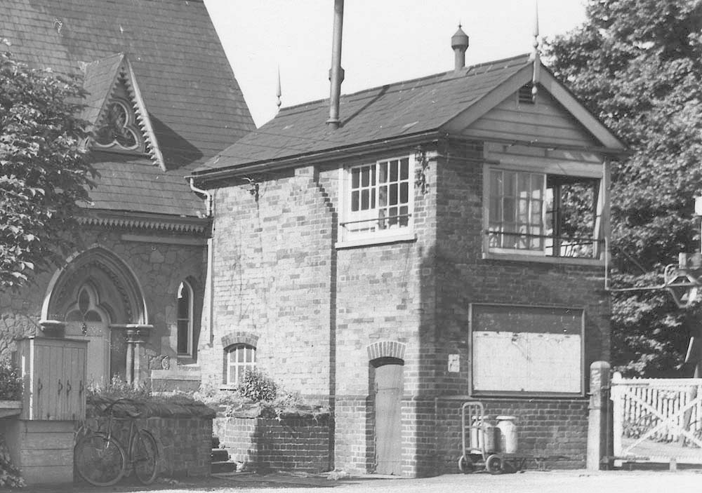 Close up view of the signal box showing the lamp fixed at angle on the corner of the box and oil storage cans used for the station lighting