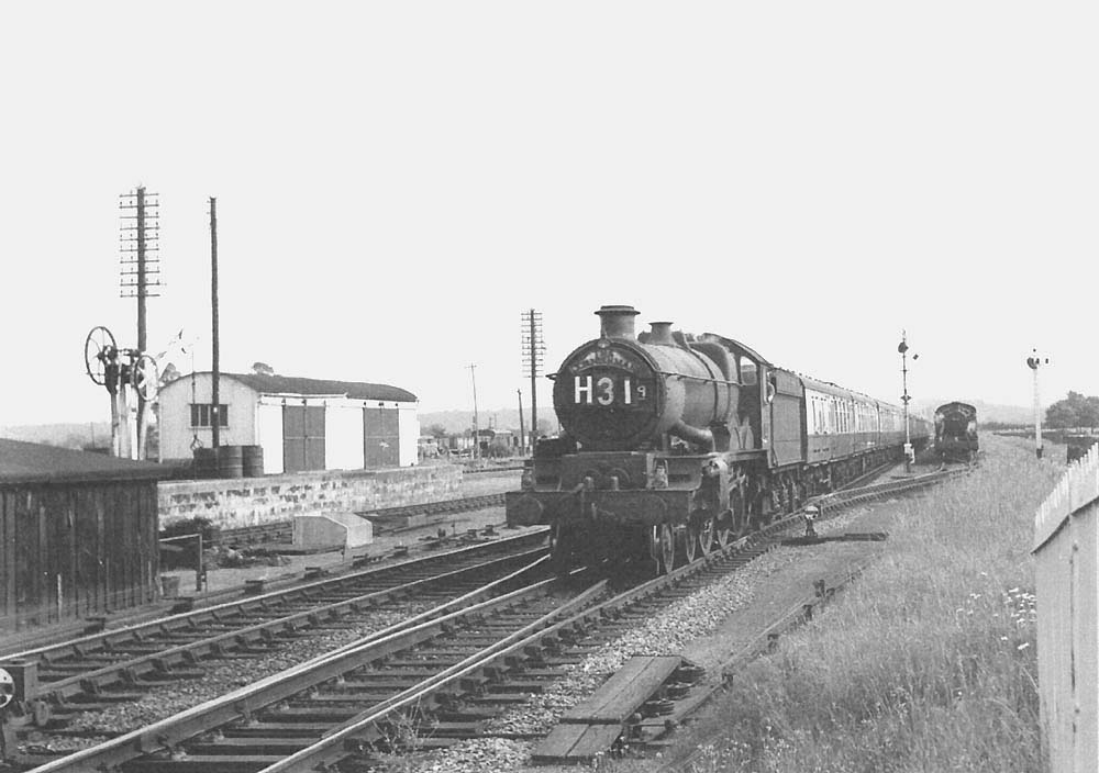 An unidentified ex-GWR 4-6-0 Castle class locomotive is seen at the head of the up 'Cornishman' as it passes a train standing in the refuge siding