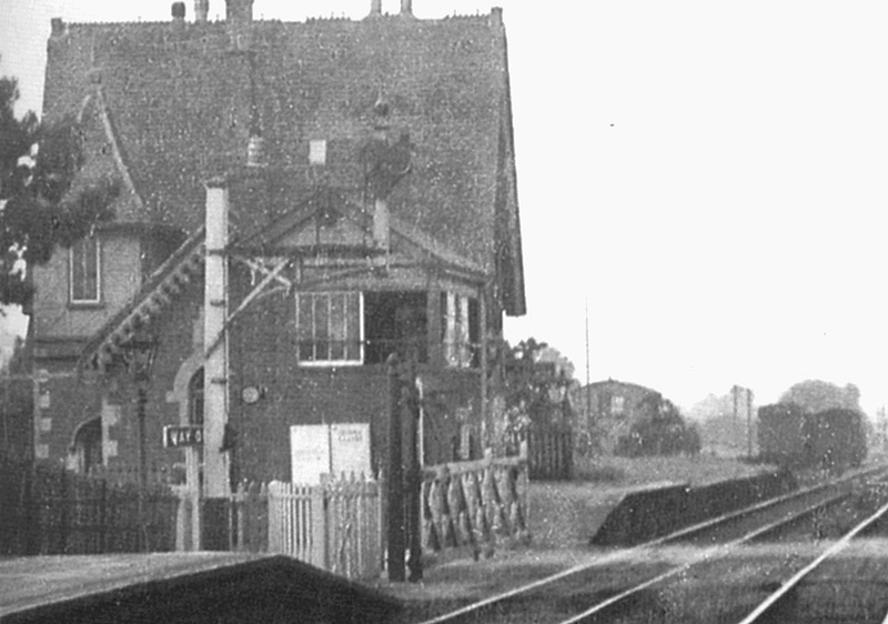 Close up showing Milcote's home starter lower quadrant signal arm on a bracket signal post with the two road goods yard beyond
