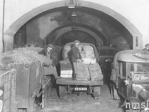 View of sacks of potatoes being loaded directly from the open 7 plank wagon on to Daimler lorries at Moor Streets lower goods shed
