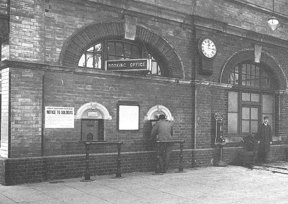 Close up of the two booking office counter positions and too the right the Station Master standing outside his office door