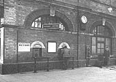 Close up of the two booking office counter positions and too the right the Station Master standing outside his office door
