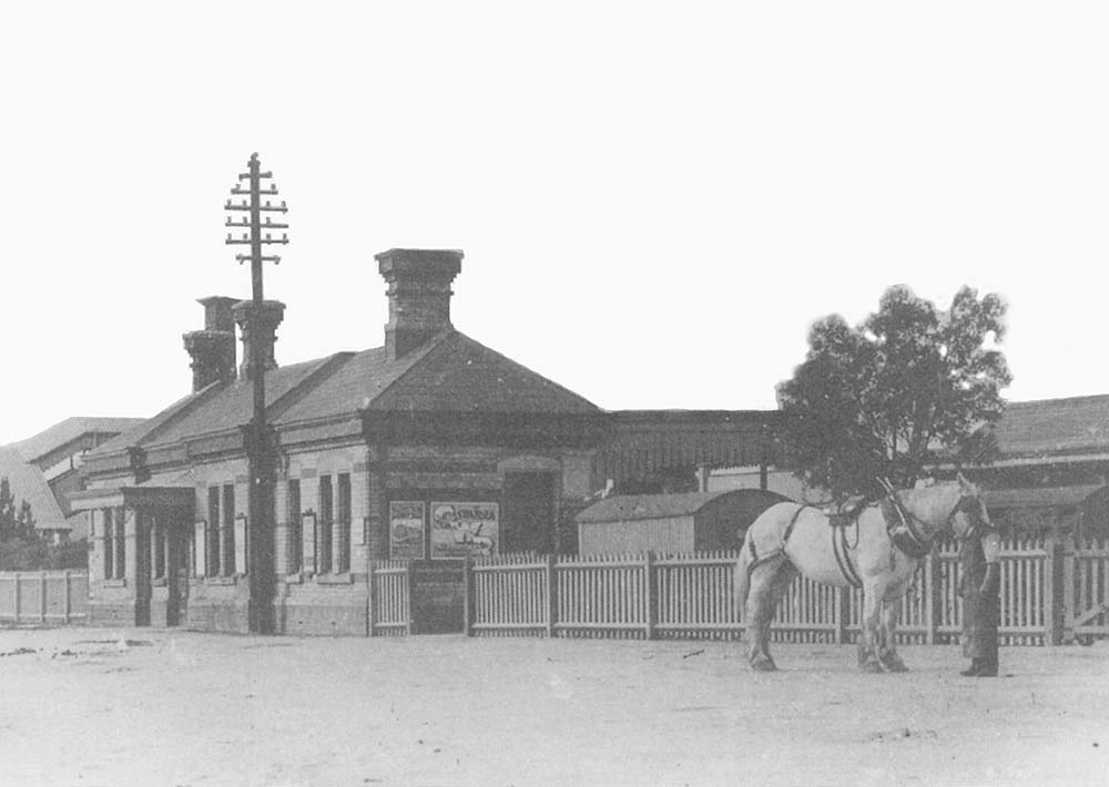 Close up showing the main station building with only a short canopy protecting the entrance to the booking hall