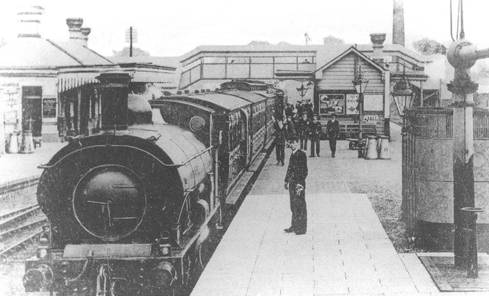 An unidentified GWR 0-6-0ST 645 class locomotive stands at Moreton-in-Marsh's up platform with express headlamps on the buffer