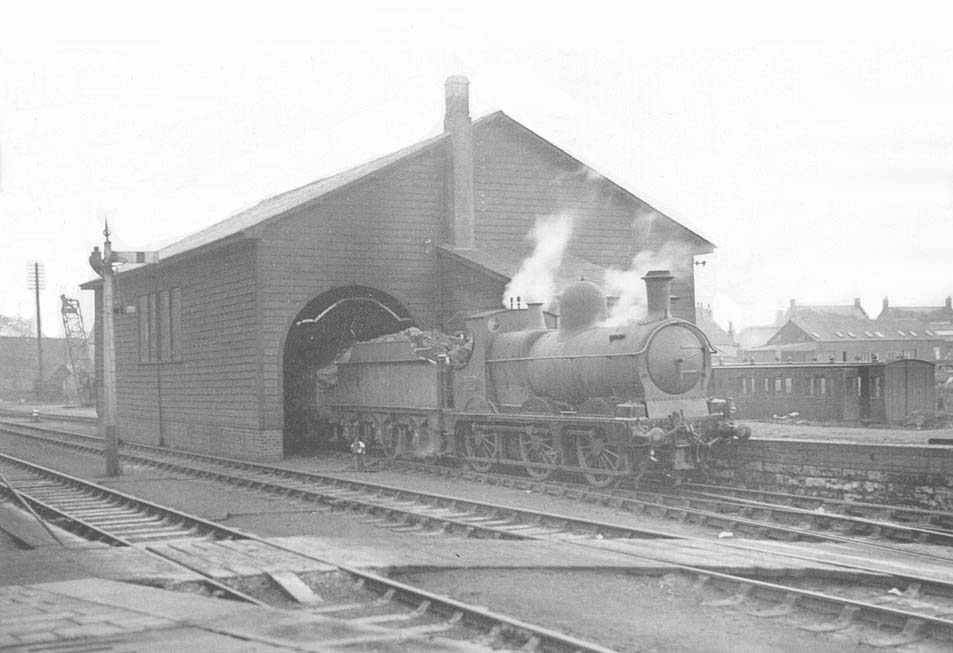 An unidentified GWR 0-6-0 'Dean Goods' locomotive is seen shunting wagons into the goods shed