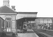 Close up of the main station building showing the entrance to the station master's office and luggage carts on the platform