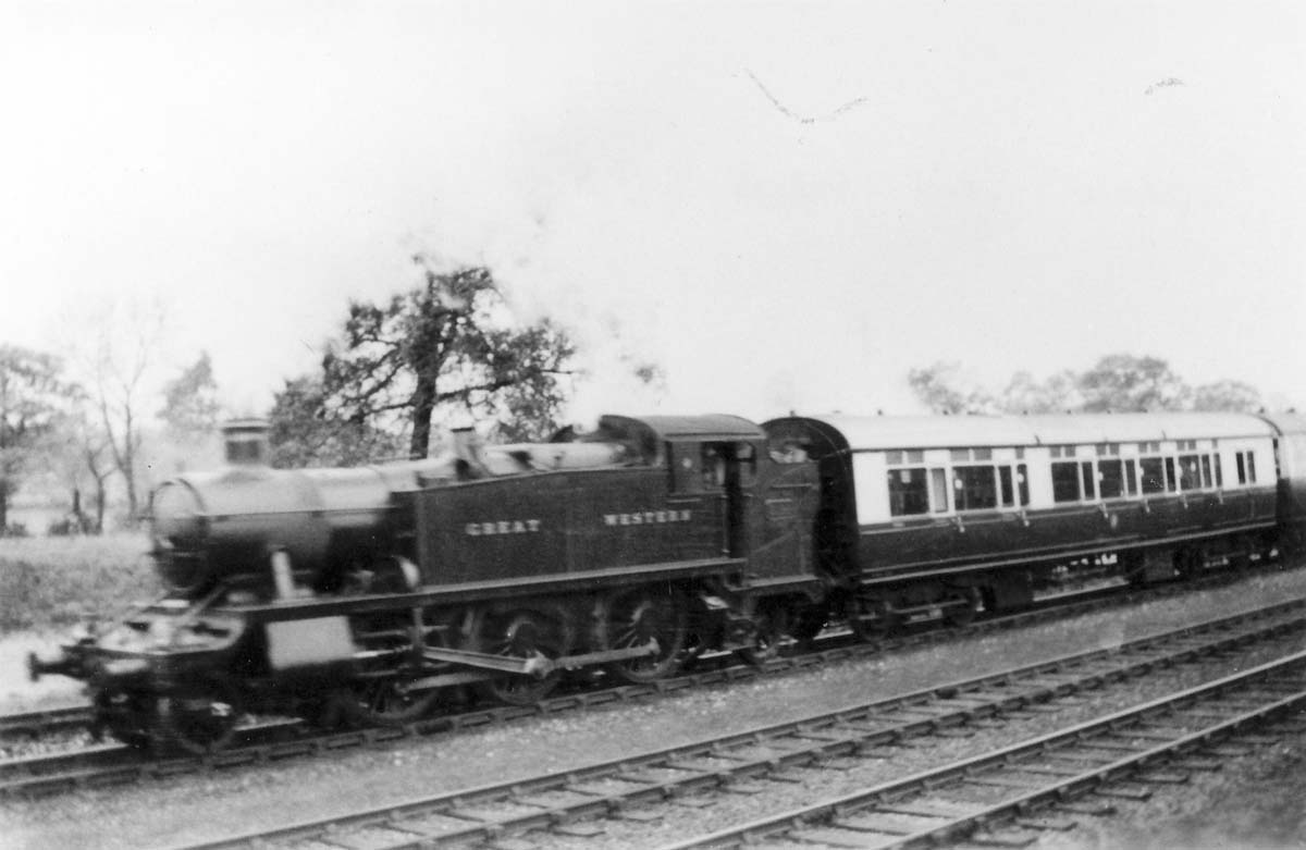 An unidentified Great Western Railway 2-6-2T 3150 class Prairie Tank hauls a diagram E94 toplight corridor brake composite coach and another coach on a section of the recently quadrupled track