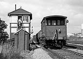 The ex-GWR guards van of a down freight is seen passes Queens Head Sidings Signal Box on 19th September 1964
