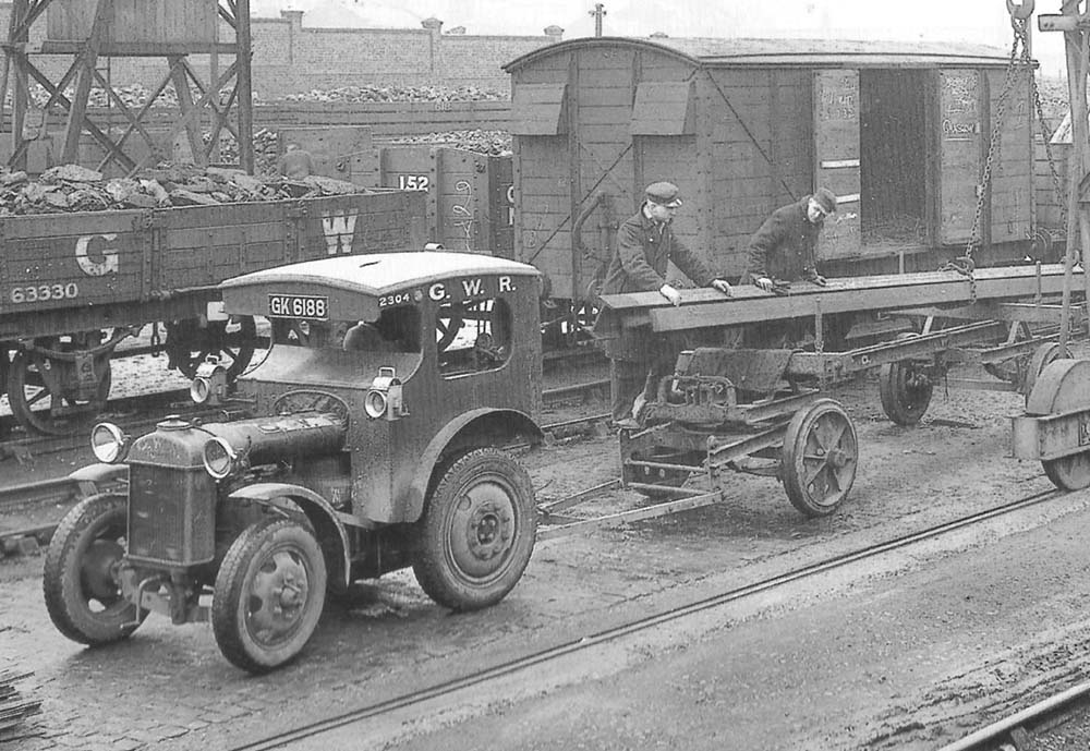 Close up showing the mechanised tractor with its trailer being loaded with steel joists