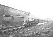 GWR 4-6-0 Saint class No 2937 'Clevedon Court' is seen a down express passing the 40,000 gallon supply tank as it picks up water at speed