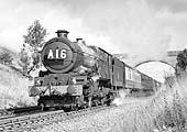 An unidentified ex-GWR 4-6-0 King Class locomotive is seen picking up water at Rowington Troughs circa 1960