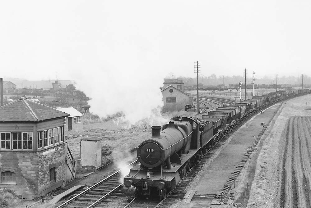Ex-GWR 2-8-0 28xx class No 2818 is seen passing Stratford on Avon Junction Signal Box on an up Class G freight service