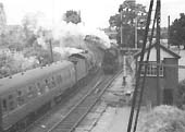 An unidentified ex-GWR 4-6-0 Hall class locomotive passes Stratford on Avon West Signal Box on an express service to Worcester