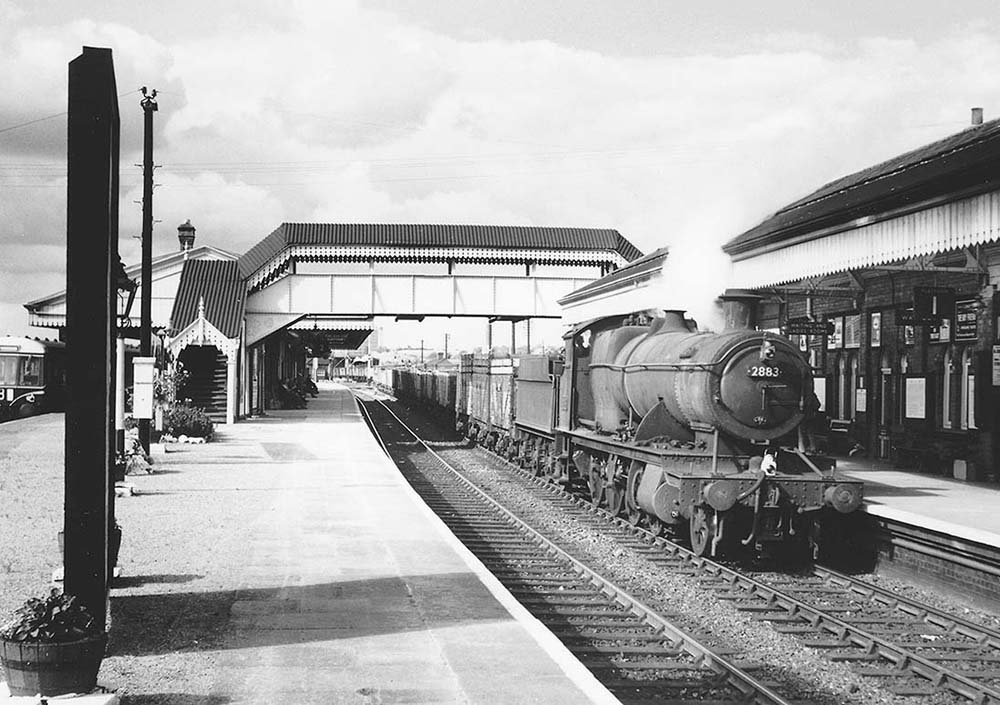 Ex-GWR 2-8-0 28xx class No 2883 is seen passing through the station on a down working to the Severn Tunnel Junction on 16th August 1958