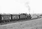 Ex-GWR 4-6-0 Hall class No 6944 'Fledborough Hall' is seen with train of empty banana vans on the connecting spur from the SMJ to GWR line on 23rd May 1964