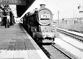 An unidentified ex-GWR 4-6-0 King class locomotive is seen passing Tyseley station's up main platform at the head of a Birkenhead to Paddington express