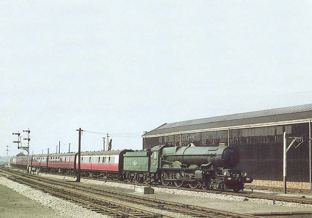 Ex-GWR 4-6-0 King class No 6017 'King Edward IV' is seen passing a goods shed on an up Birkenhead to Paddington express service on 29th August 1959