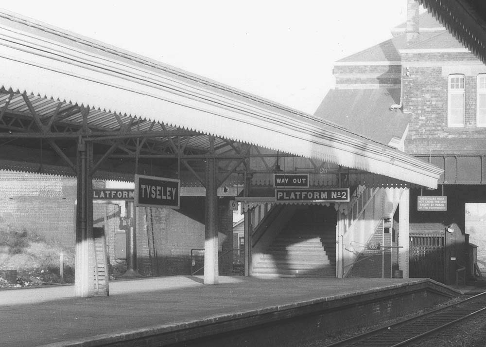 Close up showing the footbridge with the lift on the right and behind and the GWR station signs still in use in the 1950s