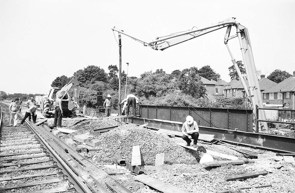 Another view of workers placing concrete into the abutment of Wharf Street bridge via a concrete pump